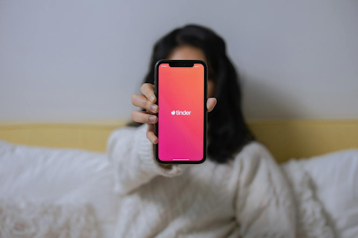 Une femme tenant un téléphone portable montrant l'application Tinder